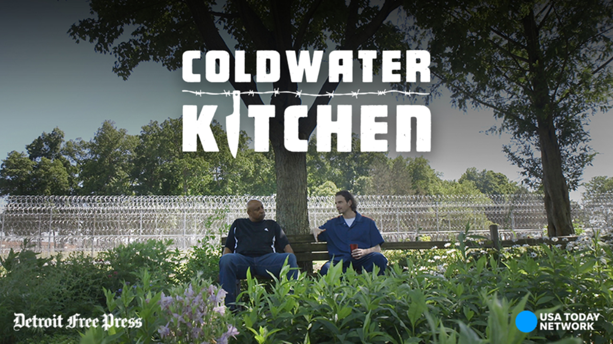 Two men sitting on a bench among trees and plants. They are chatting and the words "Coldwater Kitchen" is found above their heads.